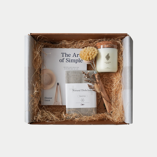The Art of Simple gift set with The Art of Simple book, The Remarkable Candle Co candle hand poured in New Zealand, Natural linen and cotton dish cloth and Tampico Fibre dish brush with wooden handle.